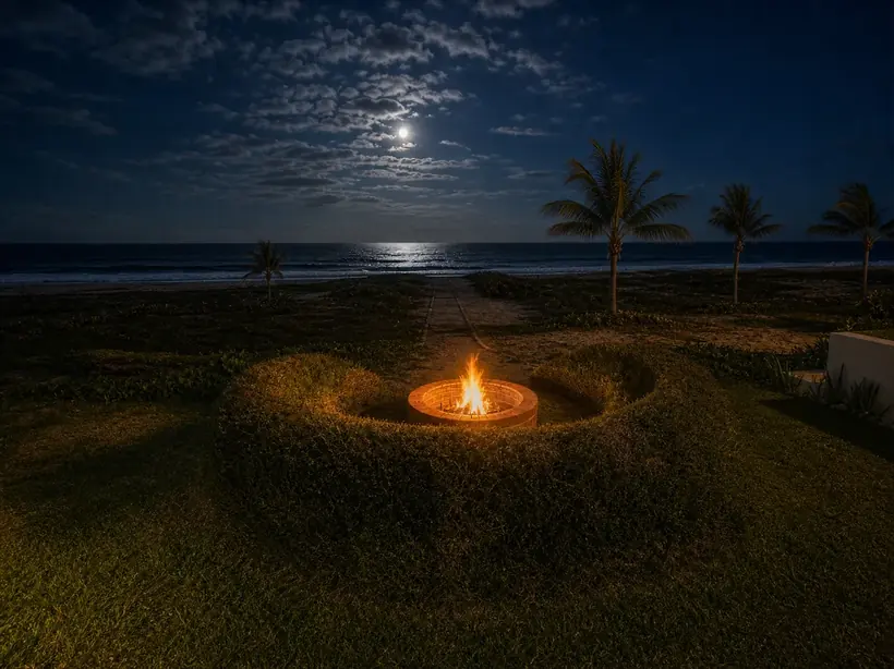 Fire pit burning calmly at night by the ocean